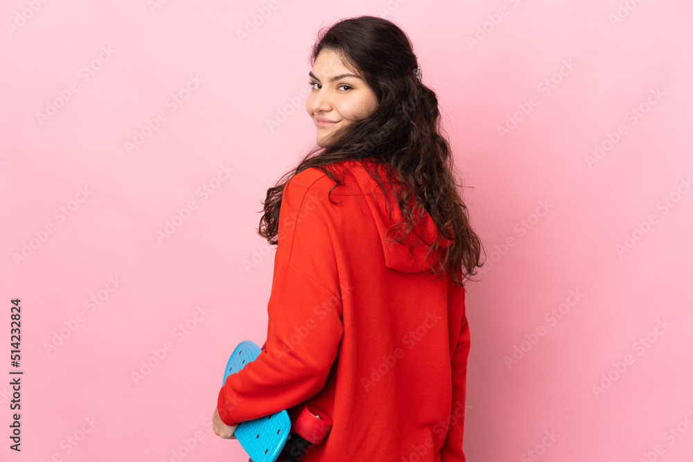 Teenager Russian girl isolated on pink background with a skate Teenager Russian girl isolated on pink background with a skate
