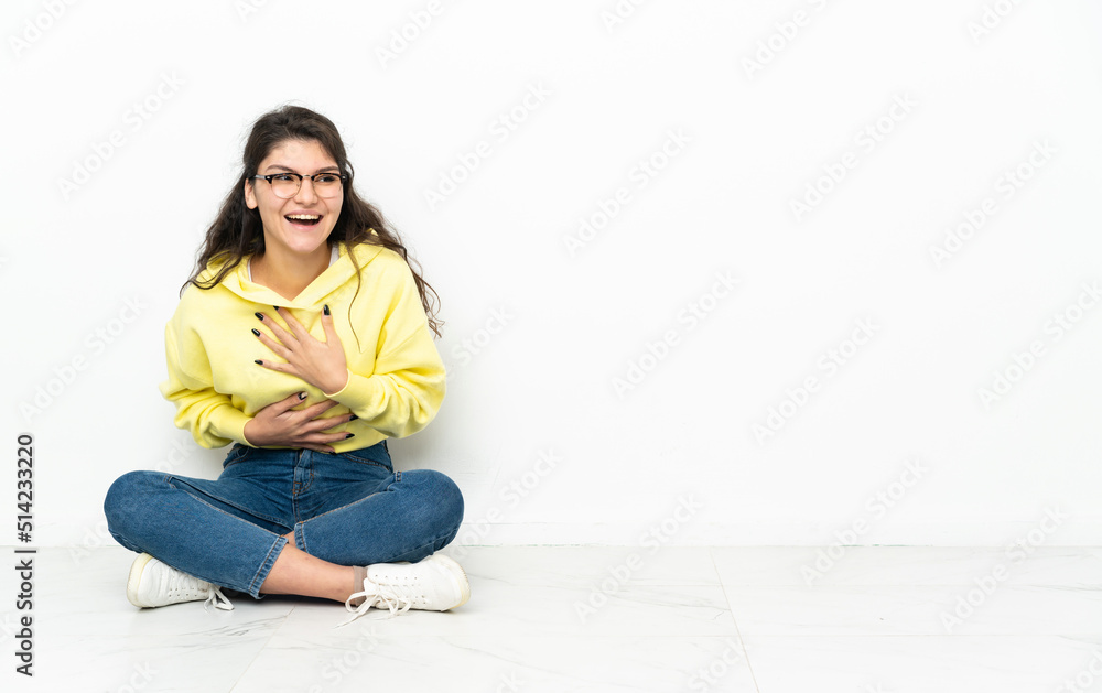 Teenager Russian girl sitting on the floor smiling a lot Teenager Russian girl sitting on the floor smiling a lot