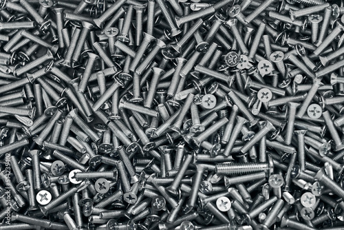 Bunch of galvanized stainless bolts with flat countersunk head, hardware background, silver screws