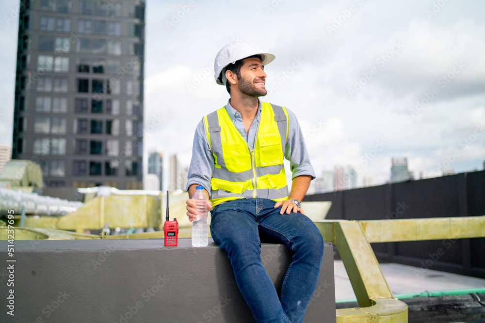 Caucasian professional engineer or technician sit on terrace of construction with relax after work and look around with happiness for success of the project. Caucasian professional engineer or technician sit on terrace of construction with relax after work and look around with happiness for success of the project.