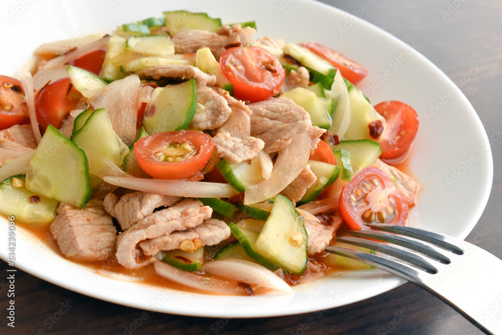 Spicy pork salad with cucumber, cherry tomatoes and onion. Healthy and dietary food concept.
