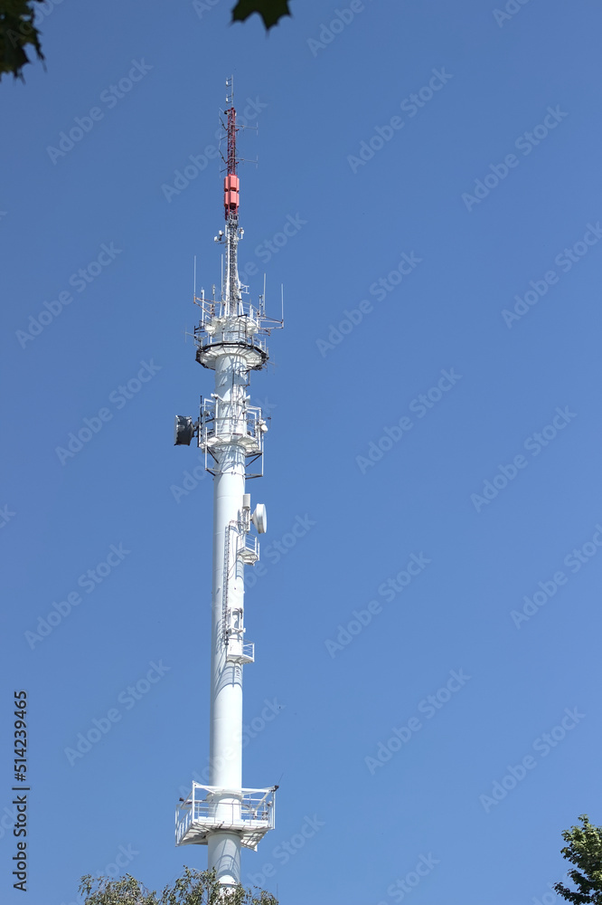 Radio broadcasting mast against the blue sky.