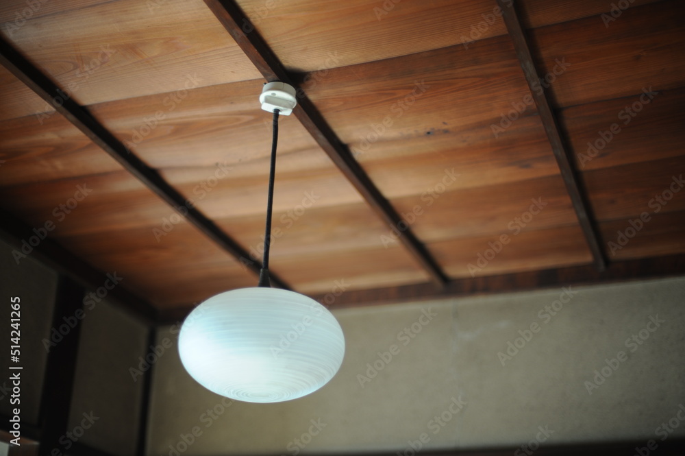 glass lamp hanging from a wooden Japanese ceiling