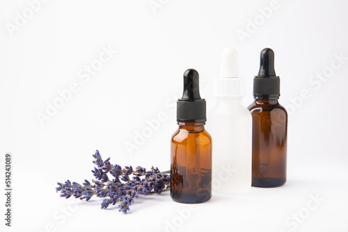 Lavender essential oil in glass bottle with pipette.Bottle with fragrant oil and lavender flowers isolated on white background.mockup of lavender essential oil with copy space.serum.