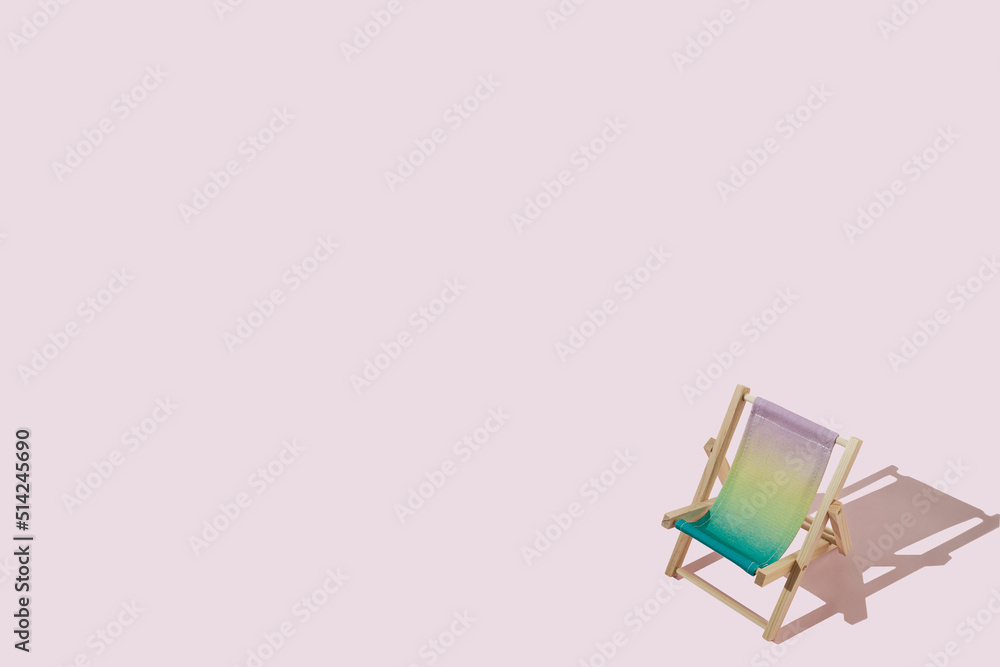 Mini colourful beach deck chair with sharp shadow against pink background. Creative summer concept with a copy space. Minimal relax and vacation idea. Mini colourful beach deck chair with sharp shadow against pink background. Creative summer concept with a copy space. Minimal relax and vacation idea.