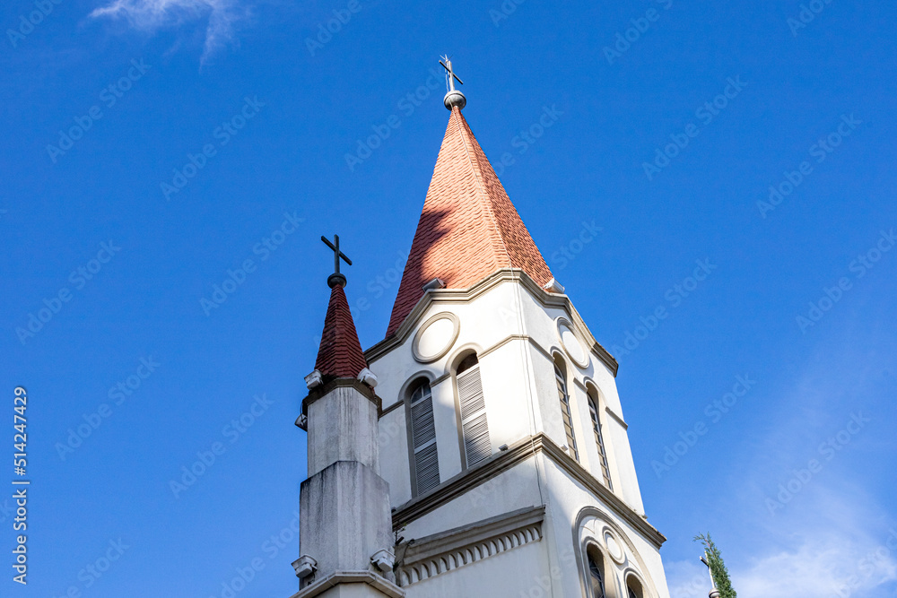 The roof of a Catholic church with crosses against the blue sky on a clear sunny day. Catholic symbols and faith. Religious buildings and architecture. The roof of a Catholic church with crosses against the blue sky on a clear sunny day. Catholic symbols and faith. Religious buildings and architecture.