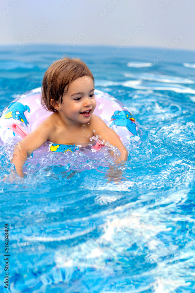 beautiful little girl smiling while playing in the pool