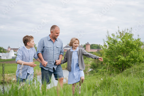 A father and his children are having fun talking on a walk.