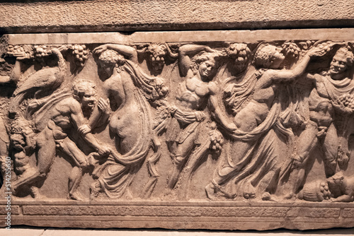 Bas-relief on the sarcophagus depicting a bacchanal led by the god of fun and wine - Dionysus photo