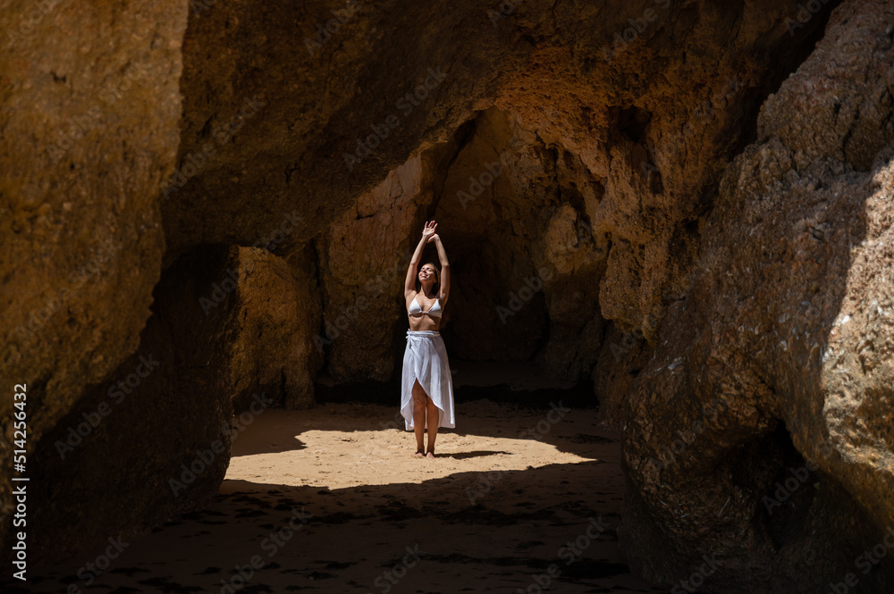 Happy woman in sunlit grotto in summer