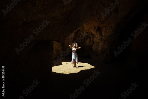 Happy woman in sunlit grotto in summer