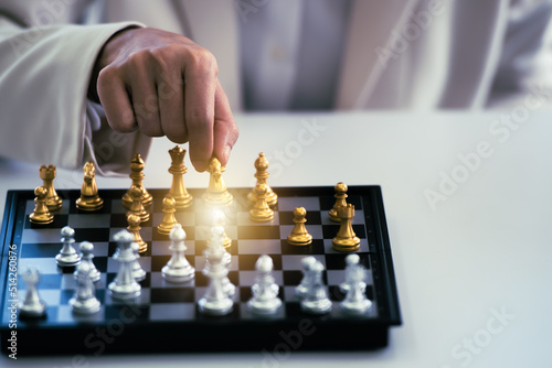 Businessman hand holding gold horse chess in competitor and win the games.