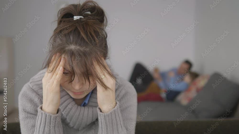 Sad woman foreground portrait focus, blurred family in background, maternal depression Sad woman foreground portrait focus, blurred family in background, maternal depression