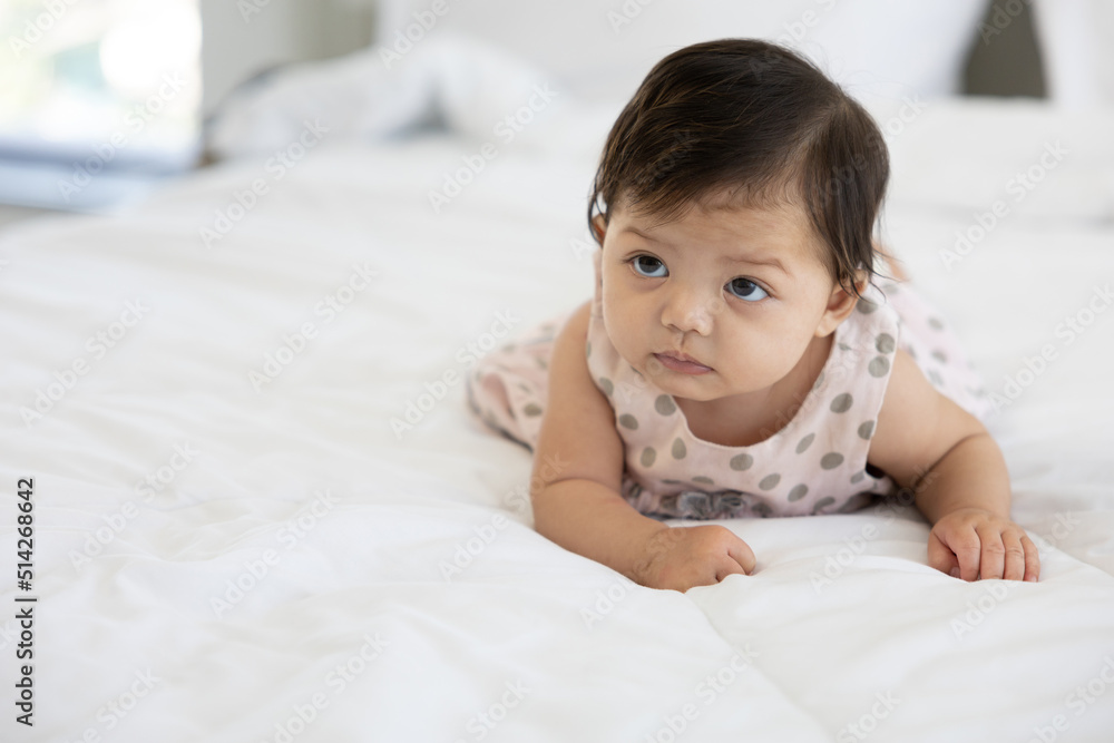 portrait cute baby crawling on bed and looking to something portrait cute baby crawling on bed and looking to something