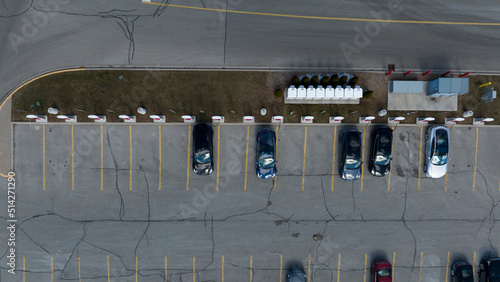 A direct overhead aerial view above a Tesla Supercharger station, cars are seen parked, charging during the day. photo