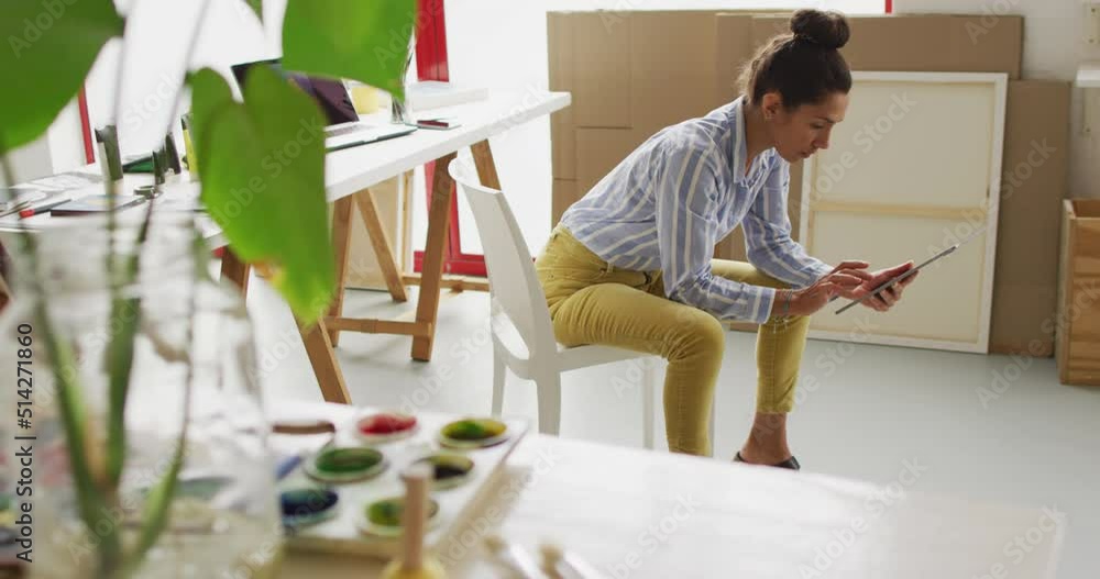 Video of happy biracial female designer using tablet in studio Video of happy biracial female designer using tablet in studio