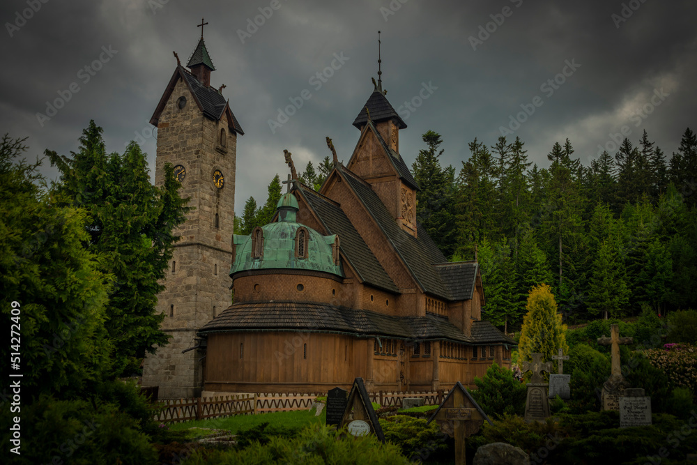 Wooden church with stone tower in cloudy spring day in Karpacz town