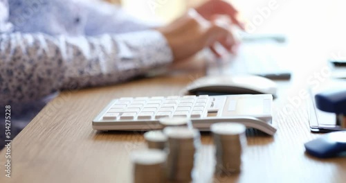 Woman uses calculator to calculate income and expenses and pay off loan