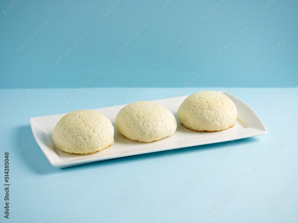 Baked crispy BBQ Honey Pork Bun served in a tray with chopsticks isolated on mat side view on grey marble background Baked crispy BBQ Honey Pork Bun served in a tray with chopsticks isolated on mat side view on grey marble background