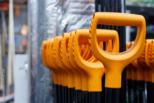Multiple orange ergonomic hand tool grips, selective focus.