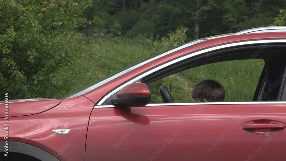 Kid on car driver seat playing and weaving hand Kid on car driver seat playing and weaving hand