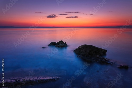 Fototapeta Naklejka Na Ścianę i Meble -  Widok skał oblewanych przez morze o wschodzie słońca przy kolorowym niebie