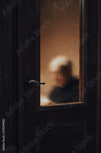 Blurred image of a priest seen through the confessional door inside a Catholic church