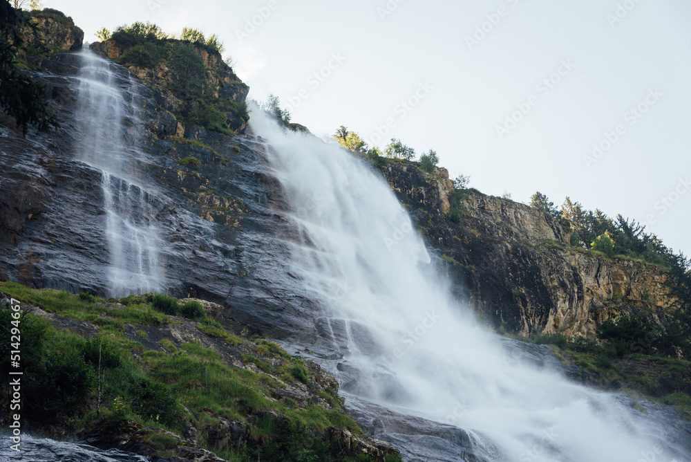 Fototapeta premium La cascade de la Fare à Vaujany. Une cascade de montagne. Une cascade dans les Alpes. Une chute d'eau avec des falaises.