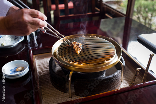 chef in japanese restaurant prepares grill to cook by rubbing with fat