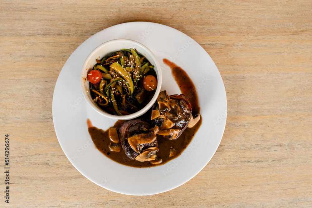Filet Mignon steaks with a mushroom sauce and a bowl of colorful vegetables Filet Mignon steaks with a mushroom sauce and a bowl of colorful vegetables
