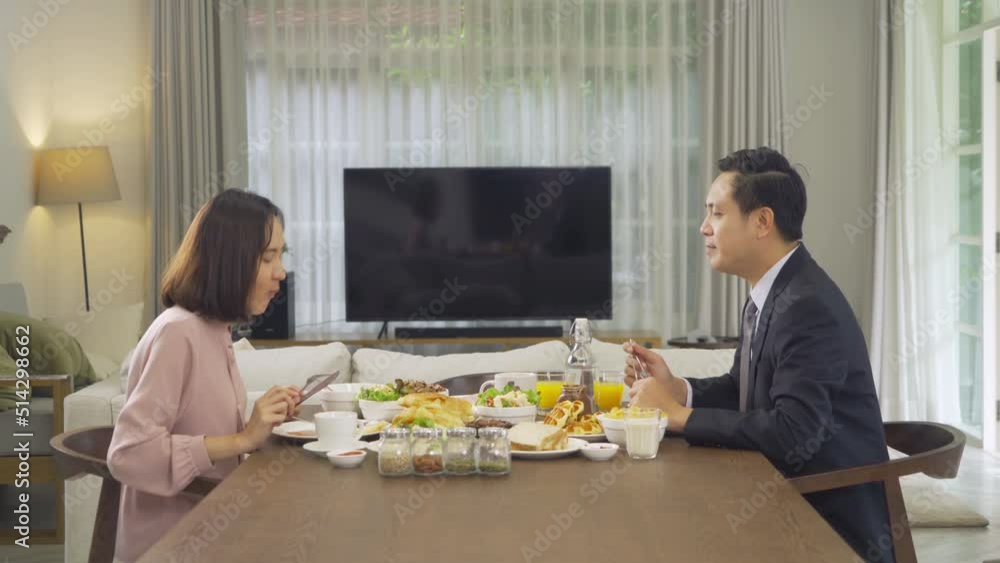 Portrait of Asian couple eating dinner or breakfast meal, food on table at home with blank screen tv. People family activity. People lifestyle celebration anniversary Portrait of Asian couple eating dinner or breakfast meal, food on table at home with blank screen tv. People family activity. People lifestyle celebration anniversary