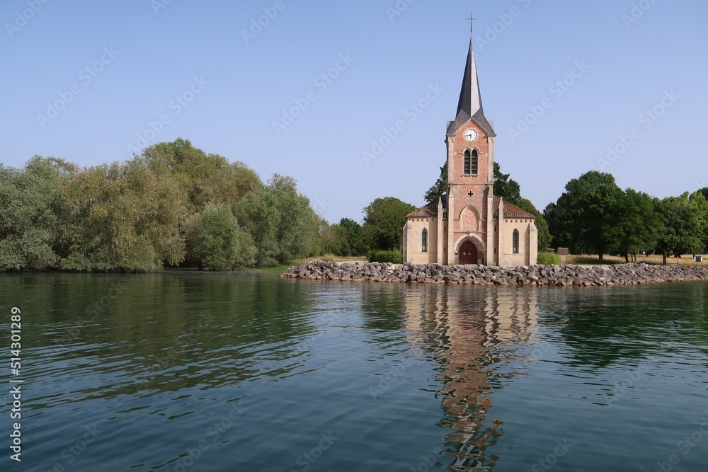 Façade de l’église de Champaubert se reflétant dans l’eau du lac du Der Chantecoq, en Champagne Ardenne, dans la région Grand Est (France)