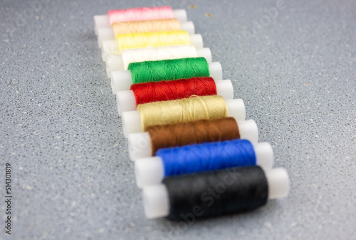 Colored spools of thread. Multicolored thread spools. Sewing production concept.
