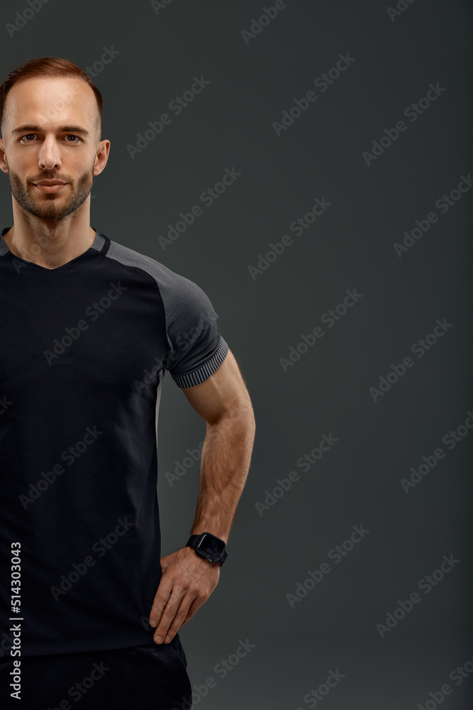 Croped portrait of male fitness model in black top. Sport banner. Grey background with space for text, Copy space.