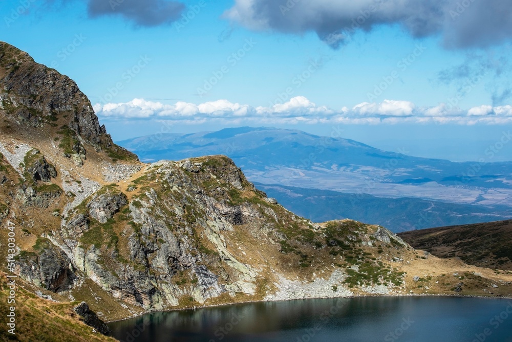 A breathtaking view of a nature reserve and mirror spring in the mountains located under an open blue sky with white fluffy clouds as a wonderful place for meditation. The trip of a day. High quality.