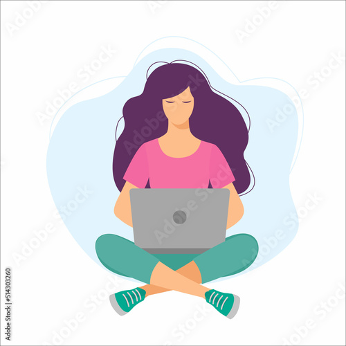 Young girl sitting on the floor on the carpet with a laptop. Woman sitting cross-legged and working on laptop.
