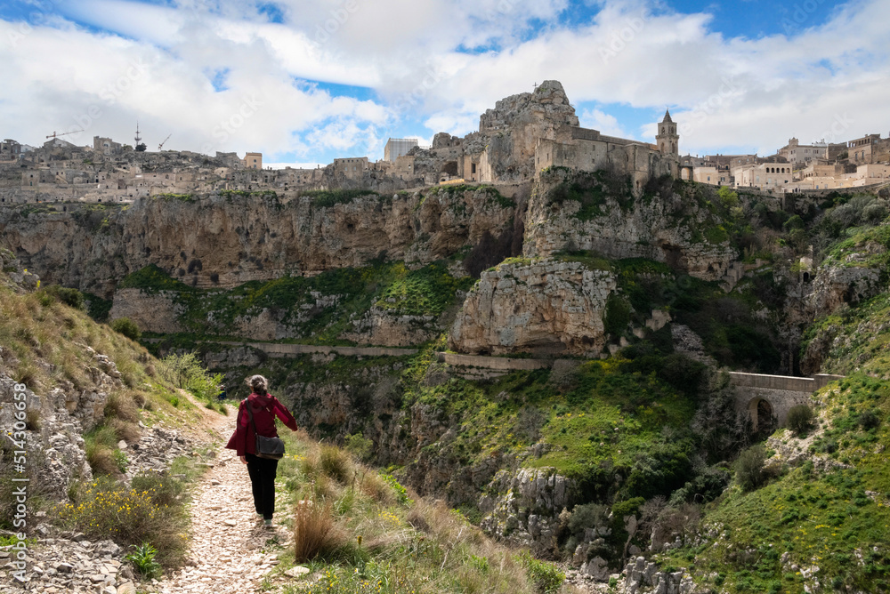 A woman hiking through the canyon of Matera, Italy