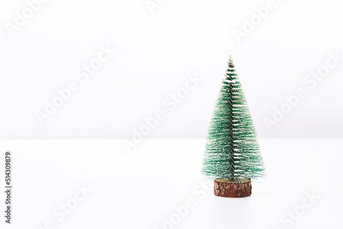 Plastic green Christmas tree on a white background. New Year and Christmas concept. Front view, copy space.