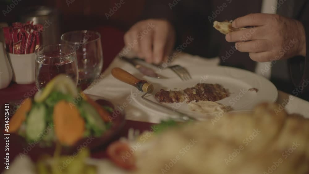 A man who tastes the horizontally cooked kebab typical of Turkish food culture and the products served with it at the dinner table. A man who tastes the horizontally cooked kebab typical of Turkish food culture and the products served with it at the dinner table.