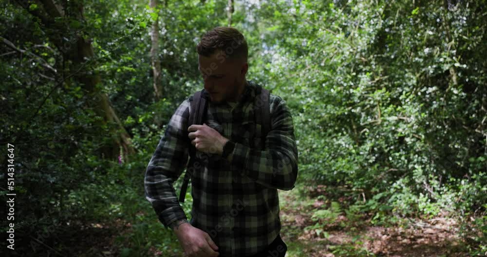 Putting a backpack on in the woods Putting a backpack on in the woods