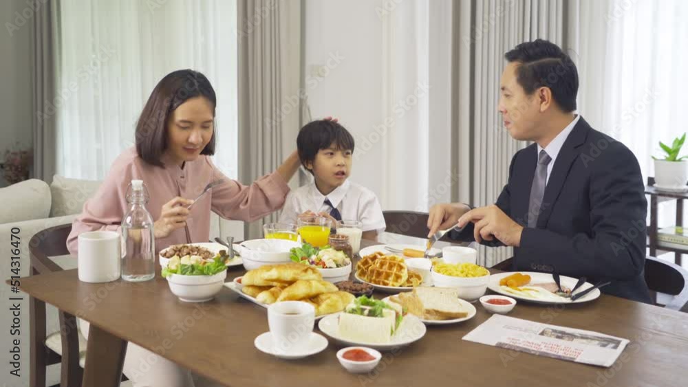 Portrait of happy smiling Asian Family eating breakfast food together before the child going to school at home. Family relationship. Love of father, mother, and son. People lifestyle. Business man. Portrait of happy smiling Asian Family eating breakfast food together before the child going to school at home. Family relationship. Love of father, mother, and son. People lifestyle. Business man.
