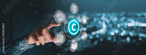 Copyright or patent concept, Business person hand holding VR screen copyright icon with blue bokeh background, Copyleft trademark license, Creation ownership against piracy crime. photo