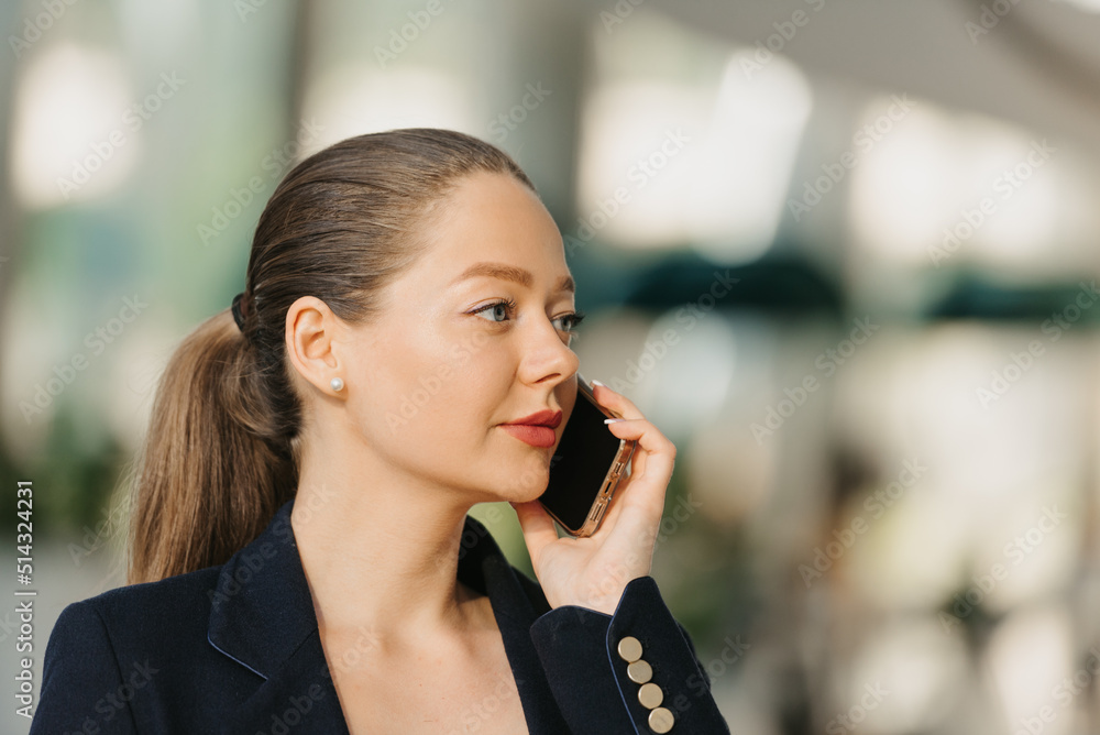 A female realtor in a blazer is working at the table in the modern lobby A female realtor in a blazer is working at the table in the modern lobby