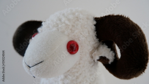soft toy sheep, a white toy sheep and it have got red eyes and brown horns,isolated photo