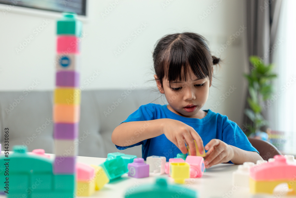 Adorable little girl playing toy blocks in a bright room Adorable little girl playing toy blocks in a bright room