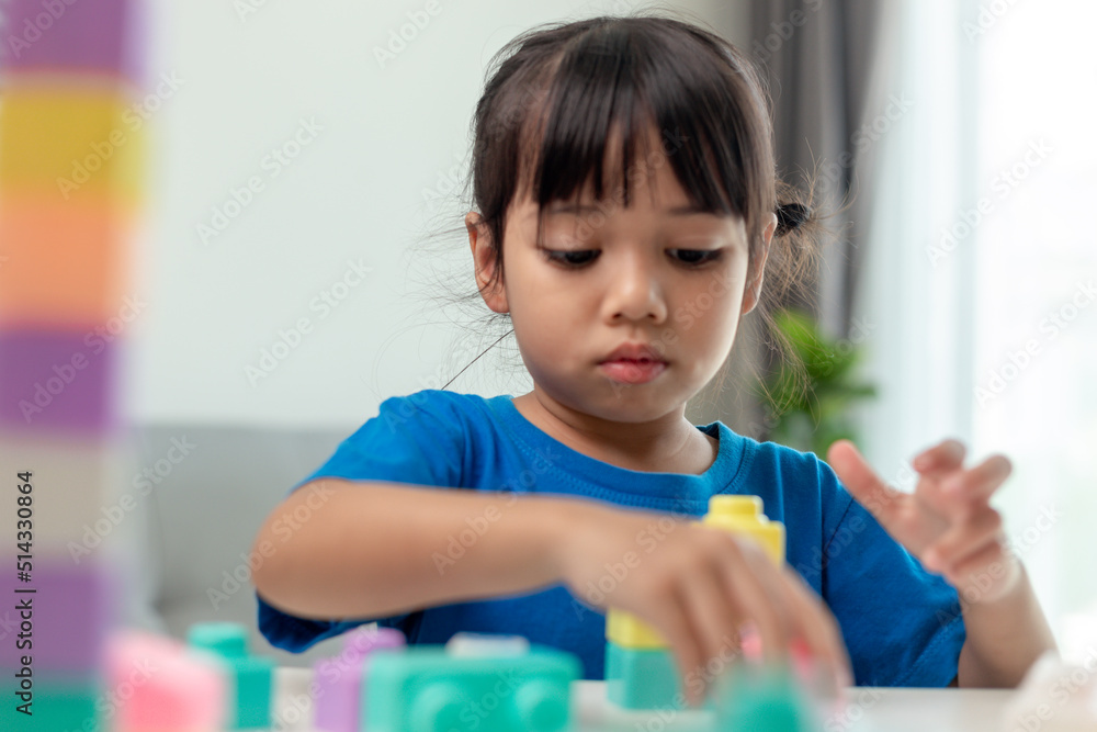 Adorable little girl playing toy blocks in a bright room Adorable little girl playing toy blocks in a bright room