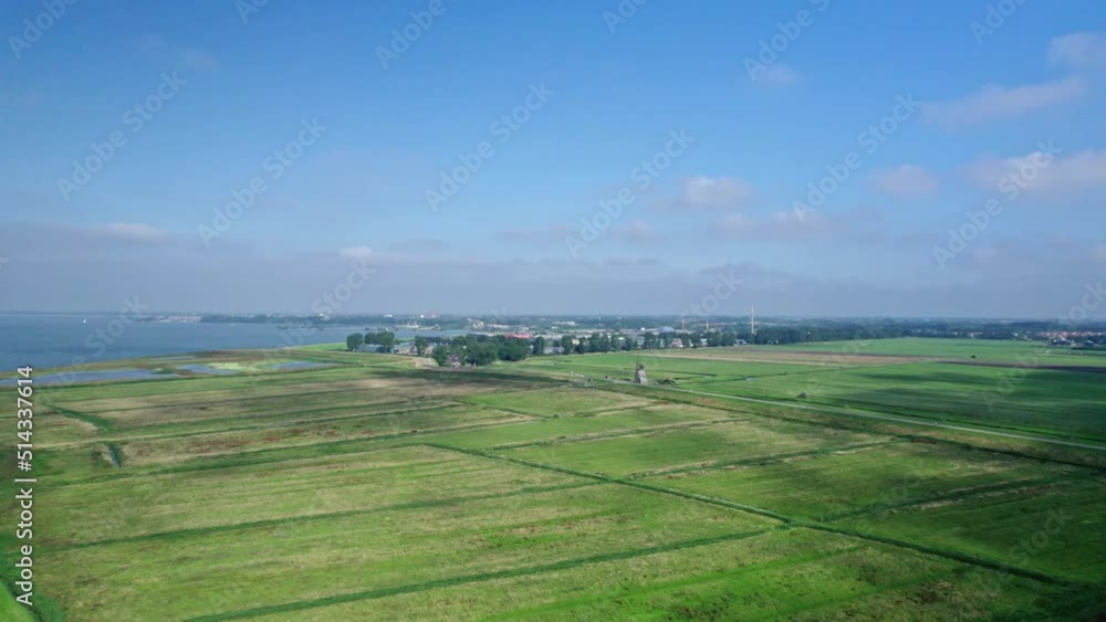 Drone panorama view: Drone emerges with a view over the polder, meadows, fields and a mill. With sailboats on the lake. In the background an industrial area and the city Hoorn in the Netherlands. Drone panorama view: Drone emerges with a view over the polder, meadows, fields and a mill. With sailboats on the lake. In the background an industrial area and the city Hoorn in the Netherlands.