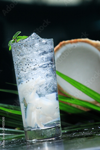 A glass of young coconut ice, nata de coco and basil seeds. Mixed with ice. background of young coconut pieces. tropical freshness