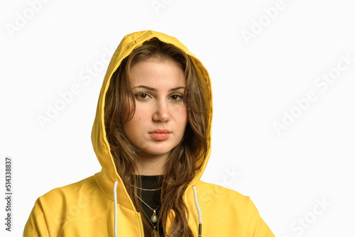 Long hair pretty young woman with noze ring. Covered head yellow raincoat with hood. isolated portrait. photo