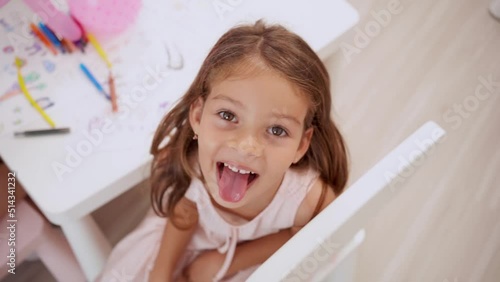 Little girl smiling in coloring and drawing classroom. Back to school and summer course.